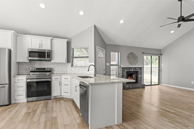 109 Campfire Cir, Copperas Cove, TX 76522 - kitchen with stainless steel appliances, vaulted ceiling, open floor plan, a peninsula, and decorative backsplash
