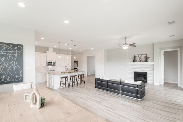 716 Dayridge Dr, Dripping Springs, TX 78620 - living area featuring ceiling fan, light wood-style floors, recessed lighting, and a tiled fireplace
