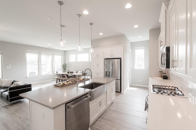 716 Dayridge Dr, Dripping Springs, TX 78620 - kitchen with stainless steel appliances, white cabinets, light wood finished floors, recessed lighting, and light countertops