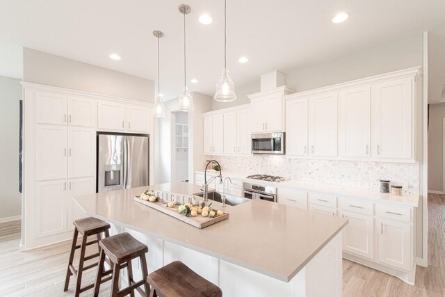 716 Dayridge Dr, Dripping Springs, TX 78620 - kitchen featuring appliances with stainless steel finishes, light wood-style flooring, white cabinetry, decorative backsplash, and recessed lighting