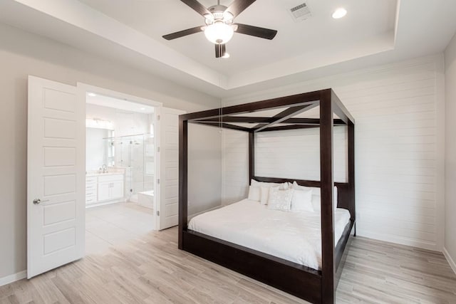 716 Dayridge Dr, Dripping Springs, TX 78620 - bedroom featuring light wood finished floors, recessed lighting, a tray ceiling, ensuite bathroom, and ceiling fan