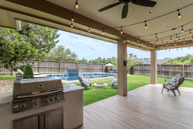 716 Dayridge Dr, Dripping Springs, TX 78620 - wooden deck with a fenced backyard, ceiling fan, a fire pit, and an outdoor kitchen