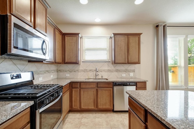 7822 Harvest Bay, San Antonio, TX 78253 - kitchen featuring appliances with stainless steel finishes, tasteful backsplash, stone counters, brown cabinetry, and recessed lighting