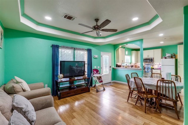 130 Los Arcos Rd, Elgin, TX 78621 - living room featuring a raised ceiling, ceiling fan, light wood-style flooring, and recessed lighting