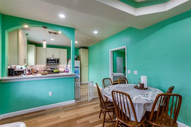 130 Los Arcos Rd, Elgin, TX 78621 - dining area featuring light wood finished floors, recessed lighting, and arched walkways