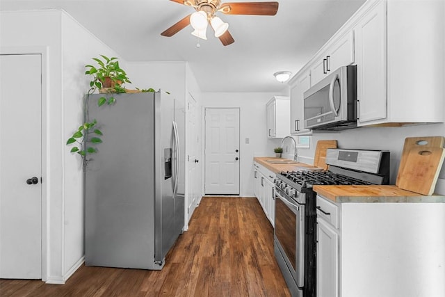 617 Johnson St, Bertram, TX 78605 - kitchen featuring appliances with stainless steel finishes, a ceiling fan, dark wood-style floors, and white cabinetry
