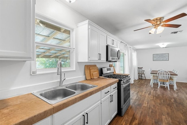 617 Johnson St, Bertram, TX 78605 - kitchen with stainless steel appliances, white cabinetry, ceiling fan, dark wood-style flooring, and light countertops