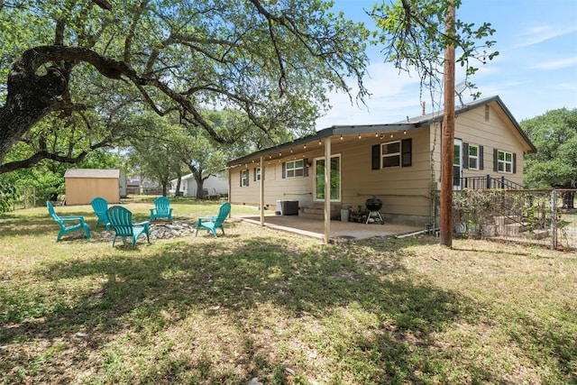 617 Johnson St, Bertram, TX 78605 - rear view of property with a storage unit, a patio, a yard, and an outdoor fire pit