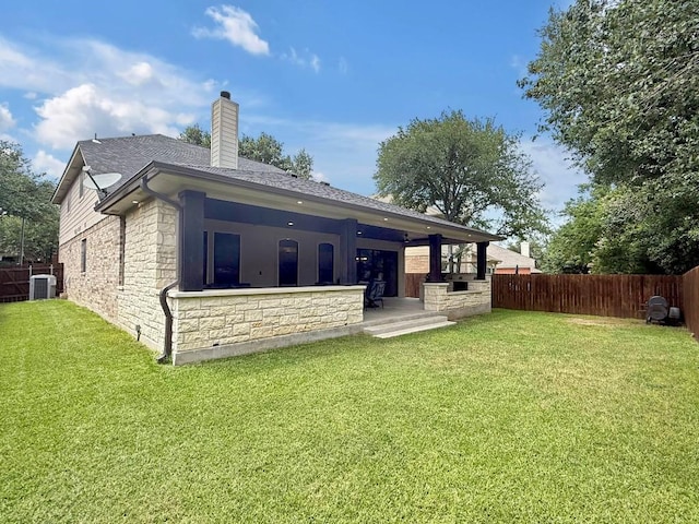 9024 Wildwater Way, Round Rock, TX 78681 - back of house with stone siding, a fenced backyard, a chimney, and a shingled roof
