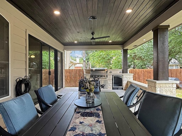 9024 Wildwater Way, Round Rock, TX 78681 - fenced backyard featuring exterior kitchen, outdoor dining space, wine cooler, and a ceiling fan