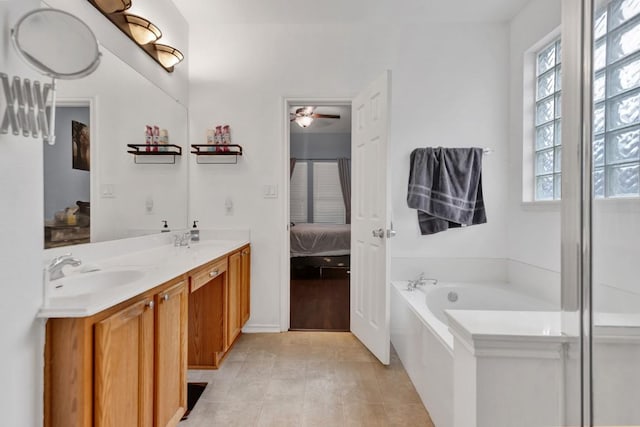9024 Wildwater Way, Round Rock, TX 78681 - ensuite bathroom with plenty of natural light, double vanity, a garden tub, and a ceiling fan