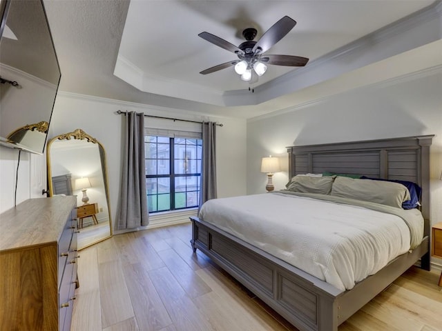 910 Blue Spring Cir, Round Rock, TX 78681 - bedroom featuring a tray ceiling, light wood finished floors, crown molding, and a ceiling fan