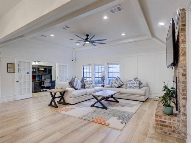 910 Blue Spring Cir, Round Rock, TX 78681 - living room with light wood finished floors, ceiling fan, french doors, a brick fireplace, and a decorative wall