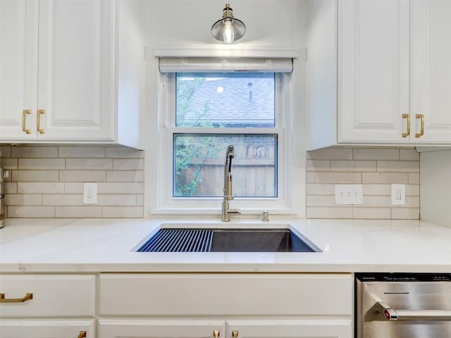 910 Blue Spring Cir, Round Rock, TX 78681 - kitchen with stainless steel dishwasher, white cabinetry, light countertops, and backsplash