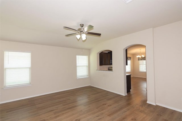 232 Reagor Dr, Taylor, TX 76574 - spare room featuring ceiling fan, a chandelier, wood finished floors, and arched walkways