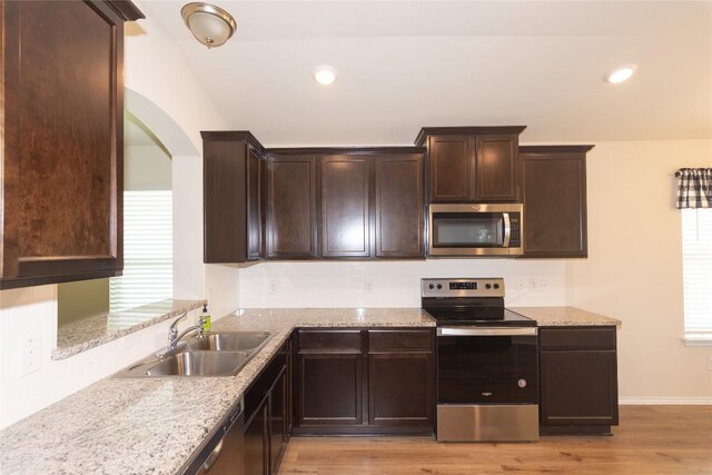 232 Reagor Dr, Taylor, TX 76574 - kitchen featuring stainless steel appliances, backsplash, light wood-type flooring, dark brown cabinetry, and recessed lighting
