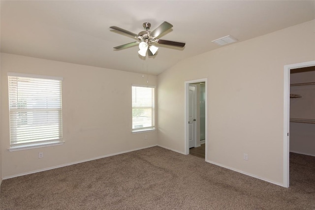 232 Reagor Dr, Taylor, TX 76574 - unfurnished bedroom featuring a spacious closet, carpet, vaulted ceiling, a closet, and a ceiling fan