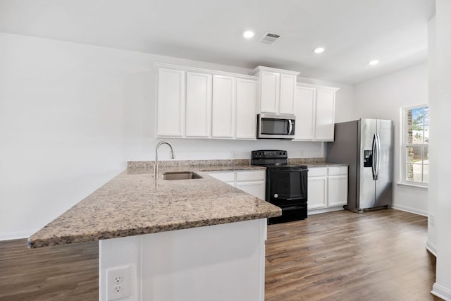 19512 Andrew Jackson St, Manor, TX 78653 - kitchen featuring appliances with stainless steel finishes, a peninsula, white cabinets, and recessed lighting