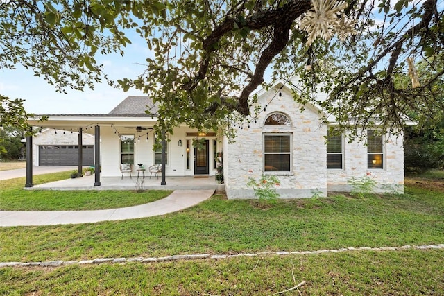 28 Long Creek Rd, Austin, TX 78737 - view of front of house featuring covered porch, a front yard, driveway, stone siding, and an attached garage
