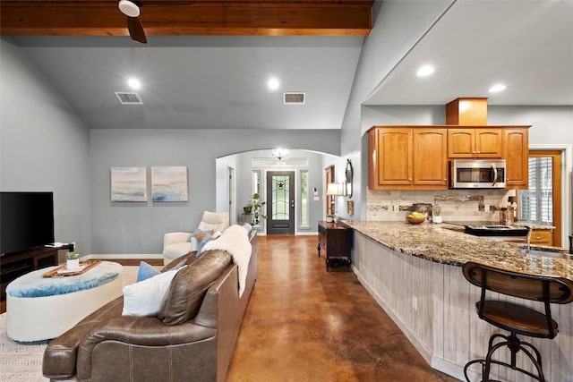 28 Long Creek Rd, Austin, TX 78737 - kitchen featuring stainless steel microwave, open floor plan, a kitchen breakfast bar, light stone countertops, and recessed lighting
