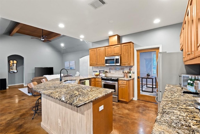 28 Long Creek Rd, Austin, TX 78737 - kitchen featuring appliances with stainless steel finishes, finished concrete flooring, a kitchen breakfast bar, a ceiling fan, and light stone counters