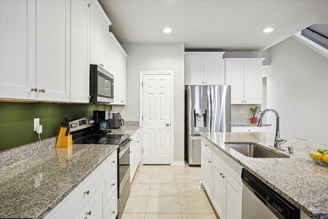 604 John Muir Trl, Leander, TX 78641 - kitchen featuring stainless steel appliances, white cabinets, light stone counters, light tile patterned floors, and recessed lighting