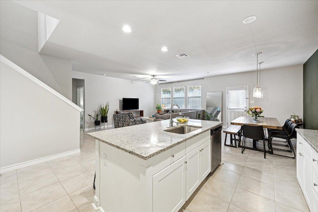 604 John Muir Trl, Leander, TX 78641 - kitchen featuring dishwasher, ceiling fan, light tile patterned floors, light stone countertops, and an island with sink