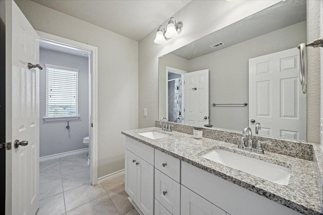604 John Muir Trl, Leander, TX 78641 - full bath with double vanity and tile patterned floors