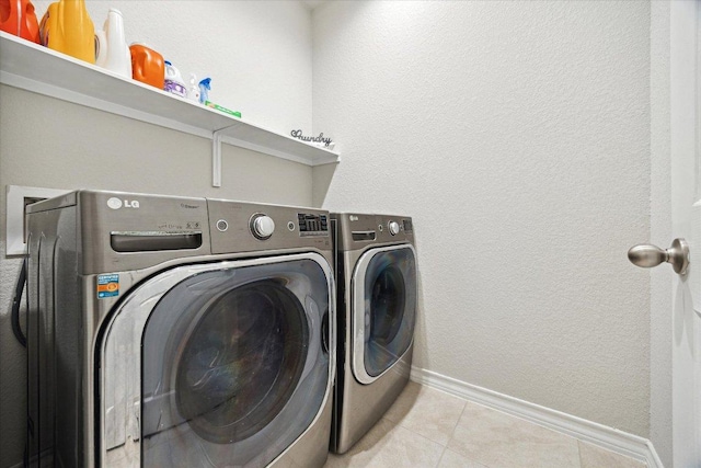 604 John Muir Trl, Leander, TX 78641 - laundry area featuring washing machine and clothes dryer and tile patterned floors