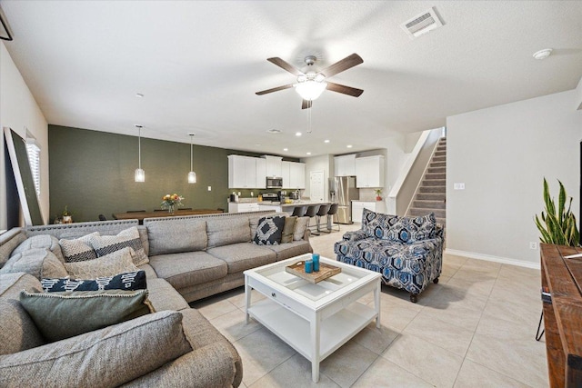 604 John Muir Trl, Leander, TX 78641 - living area featuring ceiling fan, stairs, light tile patterned flooring, and recessed lighting