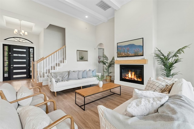 15408 Joseph Dr, Austin, TX 78734 - living room featuring wood finished floors, a high ceiling, a chandelier, a glass covered fireplace, and stairway