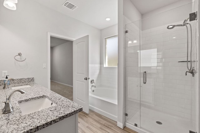 127 Tom Kite Dr, Burnet, TX 78611 - bathroom with a shower stall, a bath, double vanity, and wood finished floors