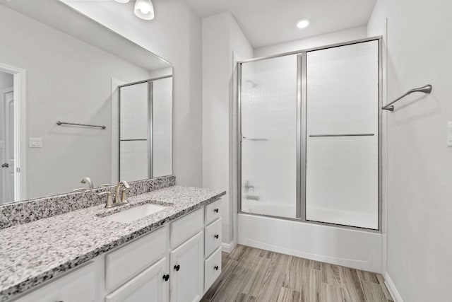127 Tom Kite Dr, Burnet, TX 78611 - bathroom with vanity, combined bath / shower with glass door, wood finished floors, and recessed lighting
