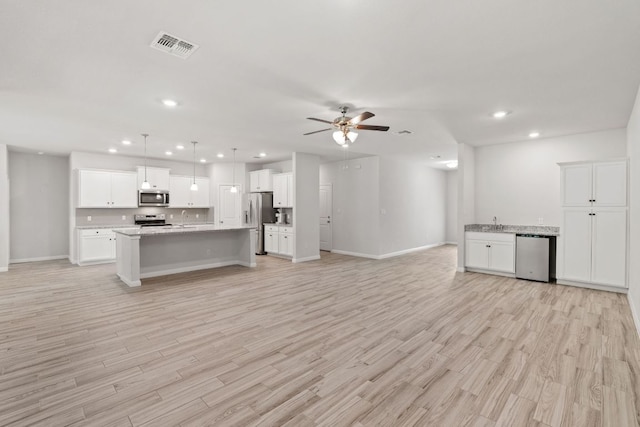 127 Tom Kite Dr, Burnet, TX 78611 - kitchen with open floor plan, stainless steel appliances, a ceiling fan, light wood finished floors, and recessed lighting