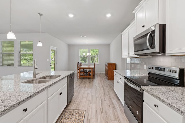 127 Tom Kite Dr, Burnet, TX 78611 - kitchen featuring appliances with stainless steel finishes, white cabinets, light wood finished floors, backsplash, and recessed lighting