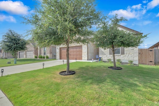 14200 James Garfield St, Manor, TX 78653 - view of property hidden behind natural elements featuring concrete driveway, a garage, and stone siding