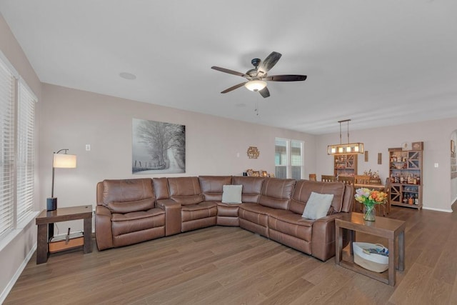 14200 James Garfield St, Manor, TX 78653 - living room featuring ceiling fan, wood finished floors, and a chandelier