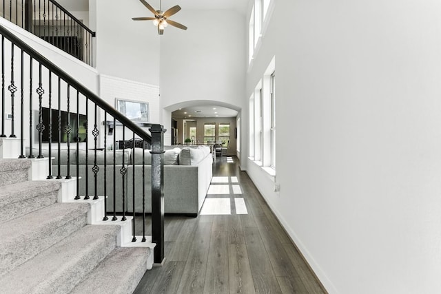 8100 Copper Prairie Bnd, Lago Vista, TX 78645 - entrance foyer with a high ceiling, a ceiling fan, dark wood-type flooring, arched walkways, and stairway