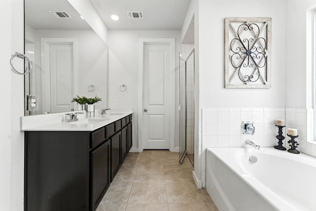 8100 Copper Prairie Bnd, Lago Vista, TX 78645 - bathroom featuring a bath, double vanity, a stall shower, tile patterned floors, and recessed lighting