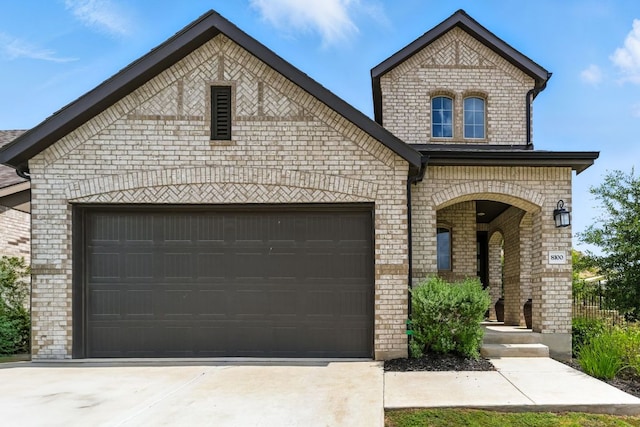8100 Copper Prairie Bnd, Lago Vista, TX 78645 - french country style house with brick siding, a garage, and driveway