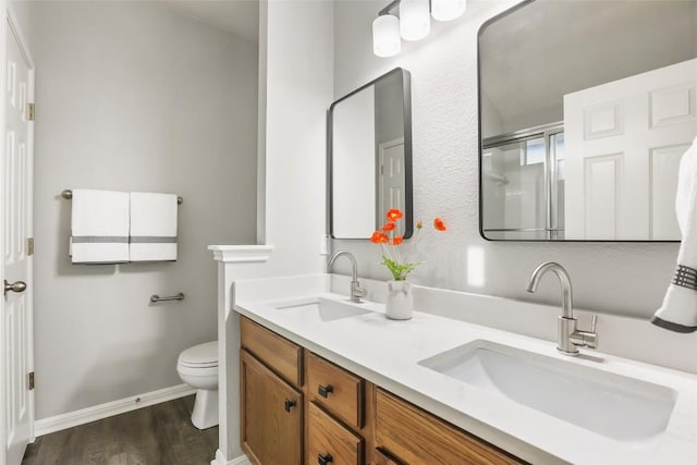 216 Watergate Way, Hutto, TX 78634 - bathroom with double vanity, wood finished floors, and a shower with shower door