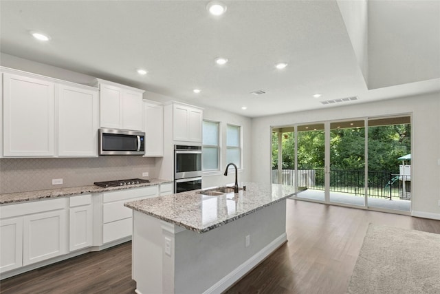 2309 Lone Spur Cv, Round Rock, TX 78665 - kitchen featuring appliances with stainless steel finishes, dark wood-type flooring, backsplash, white cabinetry, and recessed lighting