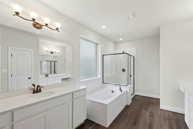 2309 Lone Spur Cv, Round Rock, TX 78665 - full bath with two vanities, a stall shower, a bath, wood finished floors, and recessed lighting