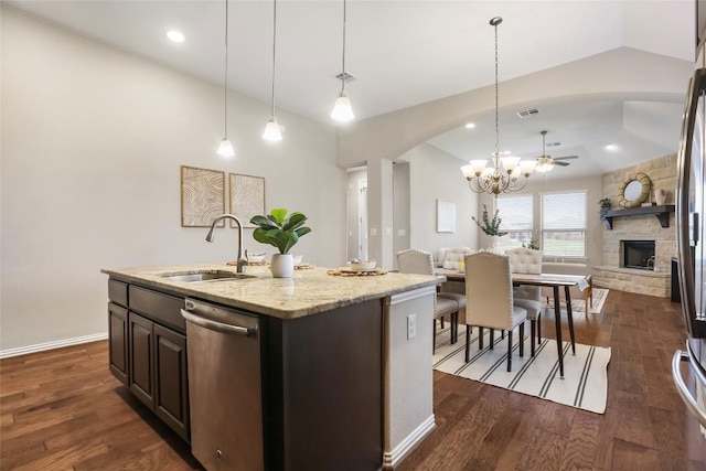 1821 Cherry Glade Trl, Georgetown, TX 78628 - kitchen with stainless steel dishwasher, arched walkways, open floor plan, a ceiling fan, and a fireplace