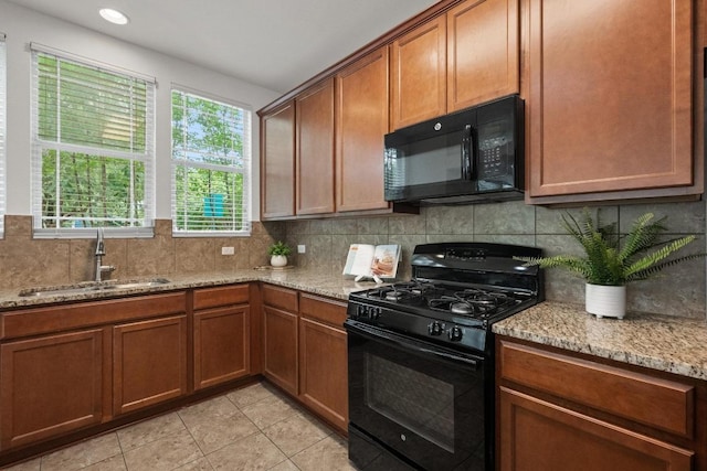 1267 Sanders, Kyle, TX 78640 - kitchen featuring black appliances, light stone countertops, decorative backsplash, light tile patterned flooring, and brown cabinets