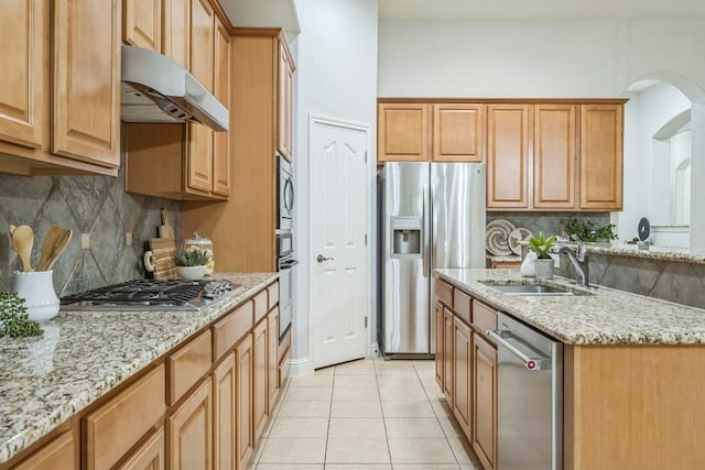 112 Mcbride Ln, Cedar Park, TX 78613 - kitchen featuring stainless steel appliances, under cabinet range hood, backsplash, and light stone counters