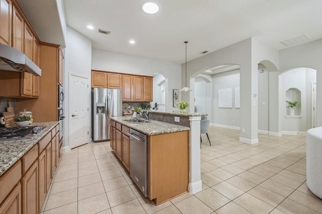 112 Mcbride Ln, Cedar Park, TX 78613 - kitchen with stainless steel appliances, light tile patterned floors, a center island with sink, arched walkways, and recessed lighting