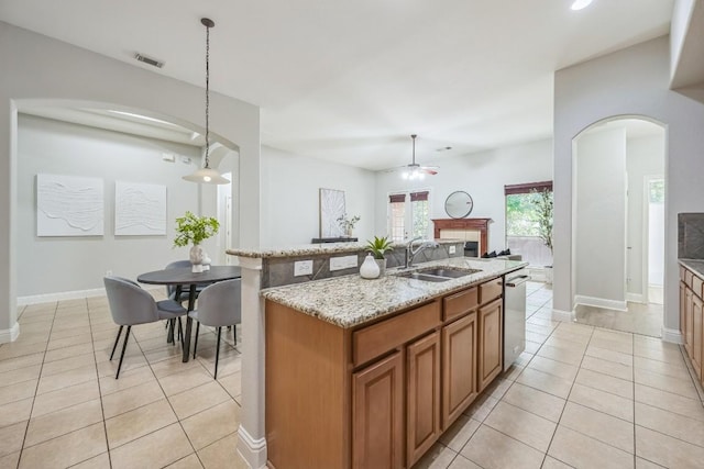 112 Mcbride Ln, Cedar Park, TX 78613 - kitchen featuring arched walkways, brown cabinetry, a ceiling fan, light tile patterned floors, and dishwasher
