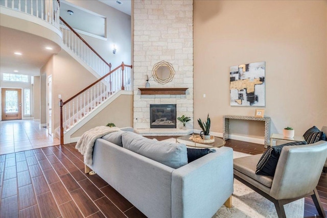 8024 Levata Dr, Austin, TX 78739 - living room with a towering ceiling, stairs, a stone fireplace, and dark wood-type flooring