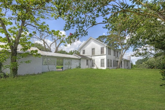 3508 Moulton Rd, Gonzales, TX 78629 - rear view of property featuring stucco siding, a yard, and a carport